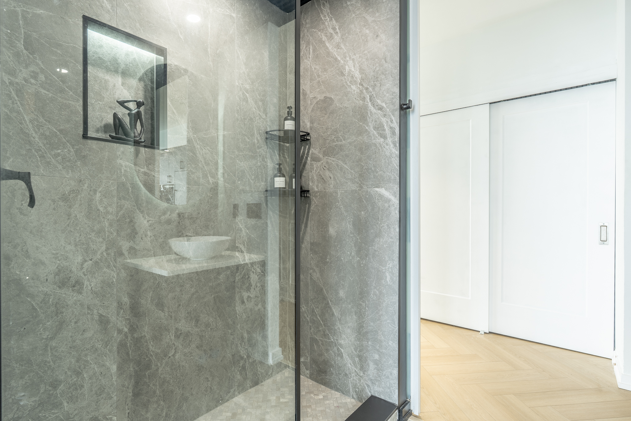 Fully renovated five-piece marble ensuite with glass shower