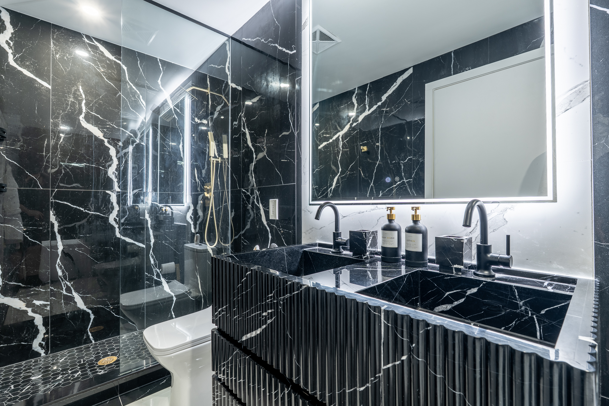 Book-matched black marble vanity with matte black fixtures